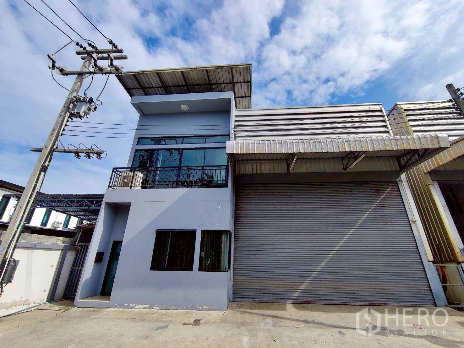 Warehouse for rent in Lam Luk Ka, Pathum Thani - Corner exterior view of the premises with canopy and driveway.