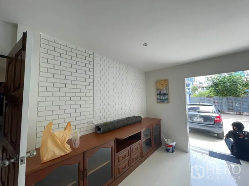 บ้าน ให้เช่าในKhlong Toei, Bangkok - โถงทางเข้าตกแต่งผนังอิฐสีขาว ตู้บิลท์อิน และมองเห็นพื้นที่จอดรถ