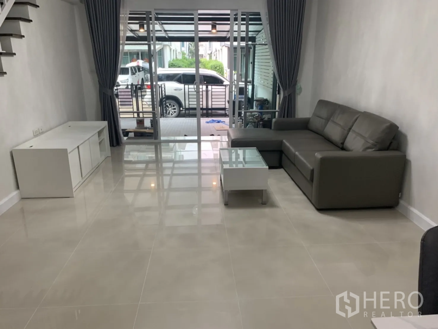 联排别墅 for rent in Bang Kapi, Bangkok - 客厅通过推拉玻璃门连接前方露台区域。