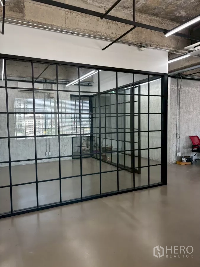 Office Space for rent in Watthana, Bangkok - Corner view of the glass meeting room and bright windows with city views and modern strip lighting.