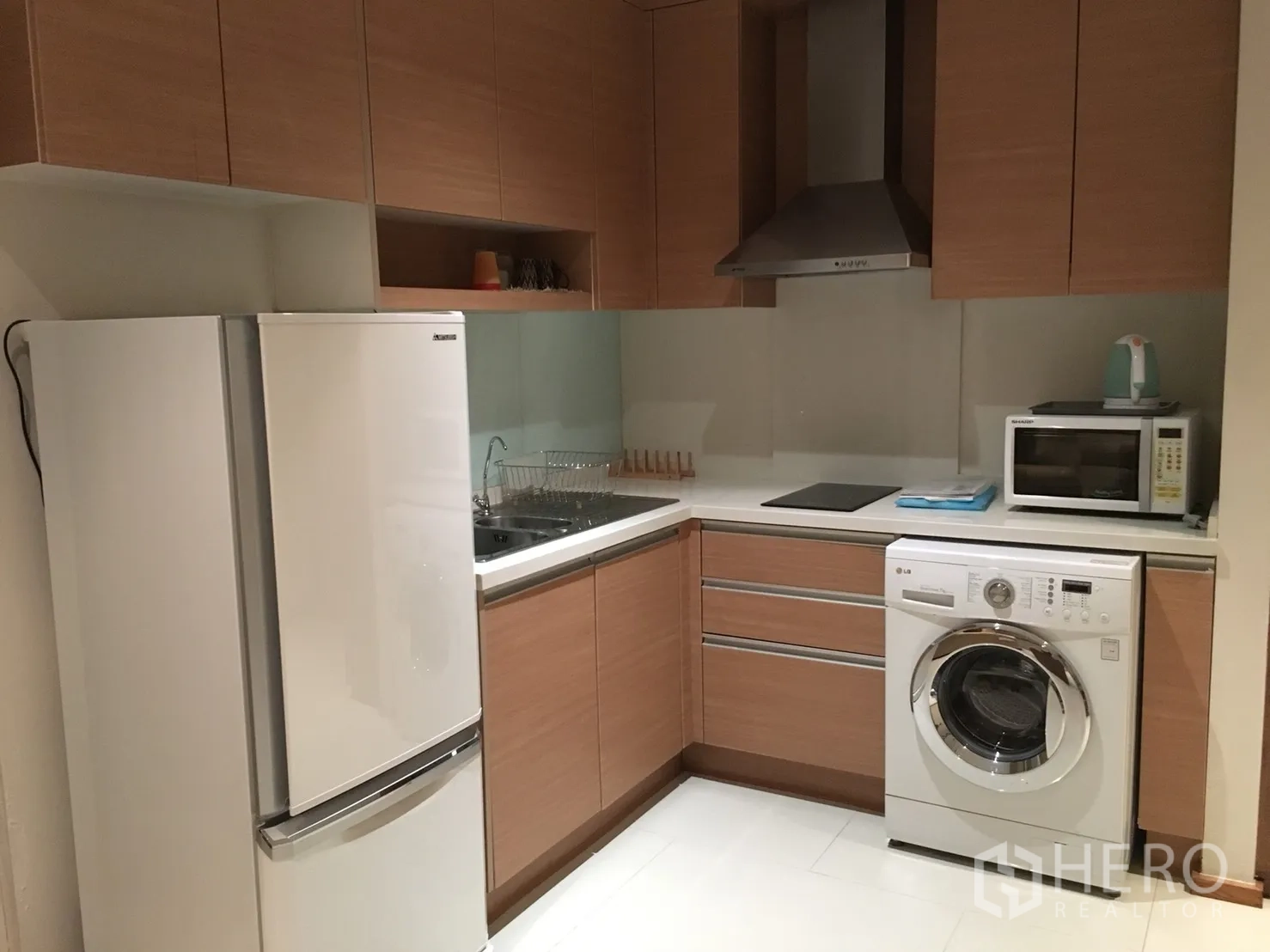 คอนโด ให้เช่าในKhlong Toei, Bangkok - ครัวรูปตัวแอลตู้ไม้ พร้อมตู้เย็น เตา เครื่องดูดควัน ไมโครเวฟ และเครื่องซักผ้า