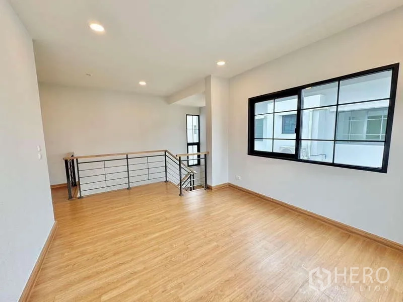 Detached House for sale in Bang Phli, Samut Prakan - Open landing with wood floors, metal railing and side window.