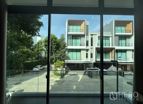 ทาวน์เฮาส์ ให้เช่าในSaphan Sung, Bangkok - มุมมองจากระเบียง เห็นถนนภายในโครงการและทาวน์โฮมสมัยใหม่รายล้อมต้นไม้