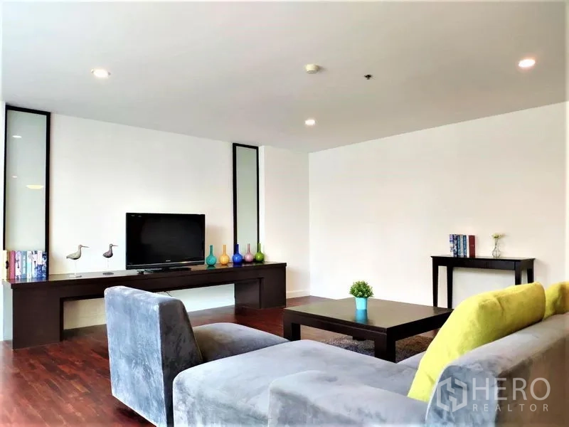 Condominium for rent in Bang Rak, Bangkok - Living room with long media console, TV, and contemporary sofa.
