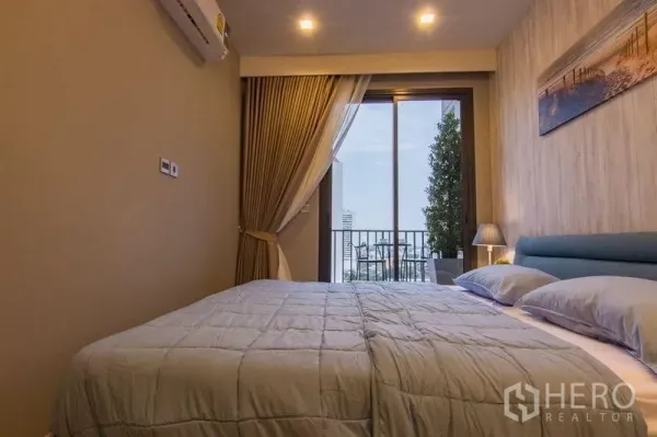 公寓 出售在Watthana, Bangkok - 温馨卧室配大床，落地滑门通往阳台，享城市景观。