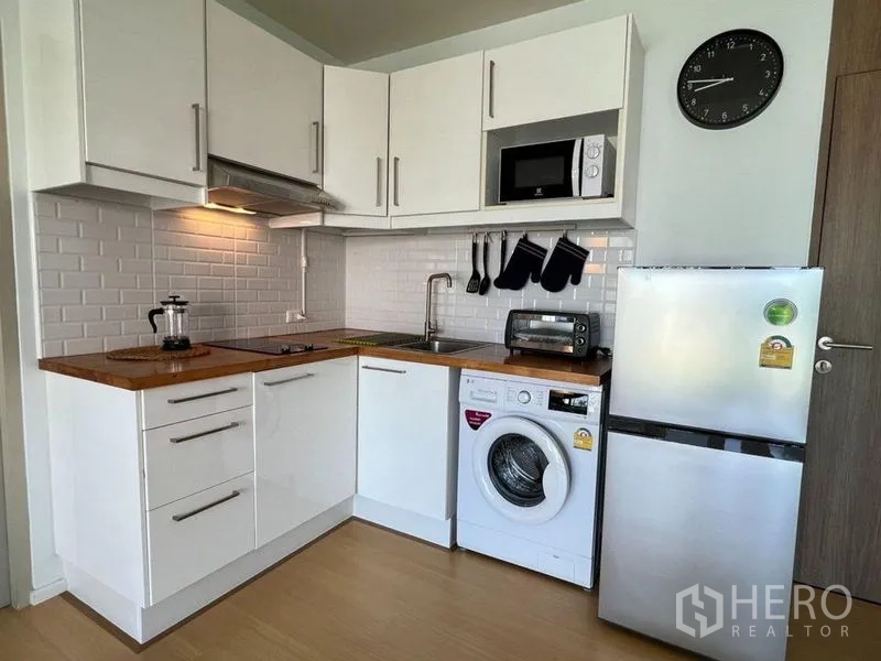 คอนโด ขายในWatthana, Bangkok - ครัวรูปตัวแอล โทนขาว เคาน์เตอร์ไม้ ผนังกระเบื้องซับเวย์ ตู้เย็นและเครื่องซักผ้า