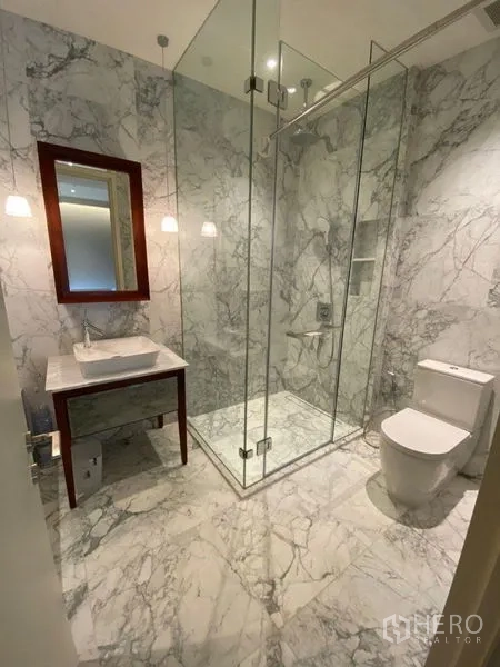 คอนโด ให้เช่าหรือขายในWatthana, Bangkok - ห้องน้ำหินอ่อน พร้อมฝักบัวกระจก อ่างล้างหน้า และโถสุขภัณฑ์ ใต้โคมไฟแขวน