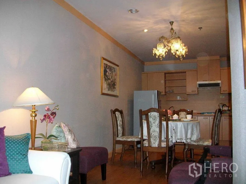 公寓 出租或出售在Khlong Toei, Bangkok - 开放式餐厨区，水晶吊灯、木质橱柜与圆形餐桌。