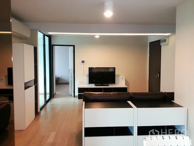 คอนโด ให้เช่าหรือขายในChatuchak, Bangkok - มุมห้องนั่งเล่นมองไปยังชั้นวางทีวี โซฟา L-Shape แอร์ และบานเลื่อน