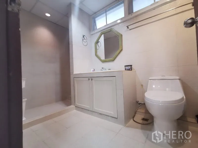 房间 出租在Khlong Toei, Bangkok - 次卫设步入式淋浴区、八角镜与洗手台。