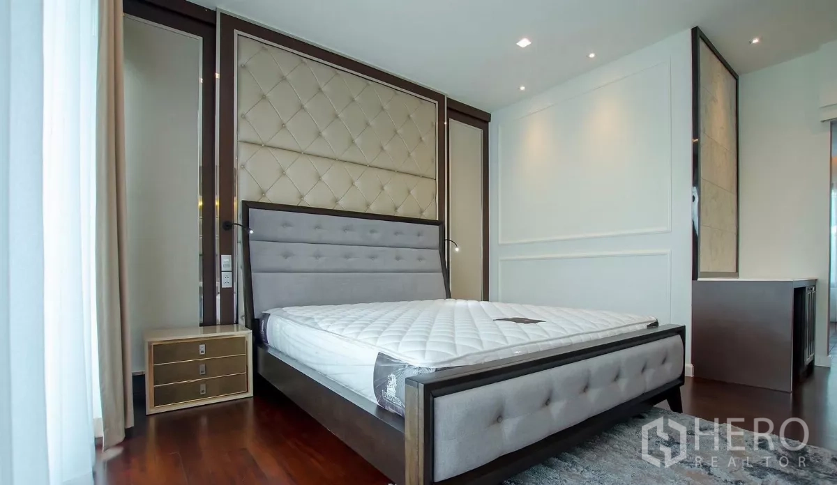 Detached House for rent in Bang Bon, Bangkok - Master bedroom with upholstered headboard, hardwood floors and bedside cabinet.
