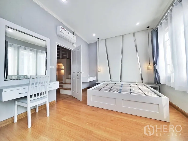 联排别墅 出租或出售在Phra Pradaeng, Samut Prakan - 主卧配床架、吊灯与梳妆台。