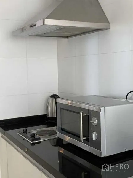 คอนโด ให้เช่าในKhlong Toei, Bangkok - ภาพระยะใกล้ของเตา ไมโครเวฟ กาต้มน้ำ และเครื่องดูดควันสแตนเลส