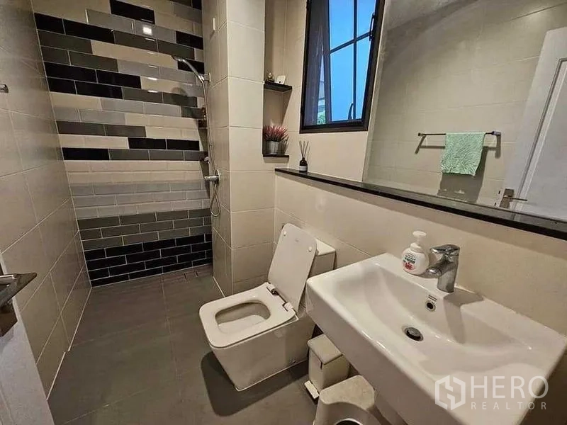 บ้าน ขายในBang Kruai, Nonthaburi - ห้องน้ำสไตล์โมเดิร์น พร้อมโซนอาบน้ำแบบวอล์กอิน กระเบื้องลายสลับ หน้าต่าง โถสุขภัณฑ์ และอ่างล้างหน้า