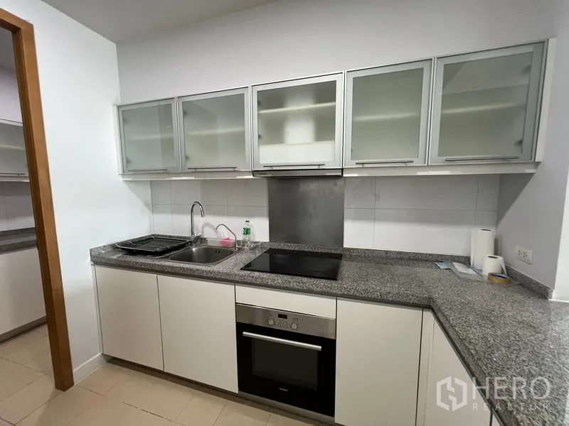 คอนโด ให้เช่าในKhlong Toei, Bangkok - ครัวสมัยใหม่ เคาน์เตอร์หินแกรนิต เตาไฟฟ้า เตาอบ และตู้แขวนกระจกฝ้า
