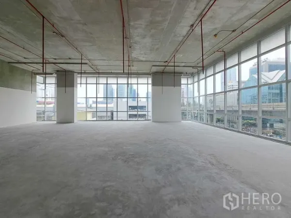 พื้นที่ขายปลีก ให้เช่าในSathon, Bangkok - พื้นที่ค้าปลีกแบบโถงโล่ง กระจกบานสูงรอบด้าน เพดานโชว์งานระบบ พื้นคอนกรีต มองเห็นวิวเมืองและแนวรถไฟฟ้า BTS ในย่านสาทร กรุงเทพฯ