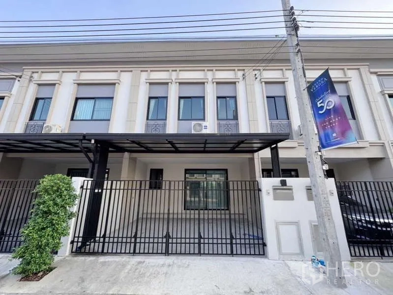 Townhouse for rent in Min Buri, Bangkok - European-inspired townhouse facade with secure metal gate and covered carport in Min Buri.