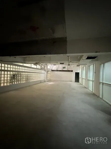 零售空间 出租 - 空置零售空间，侧墙为玻璃砖，窗扇采光，吊顶走管，后方带出入口，布局灵活。