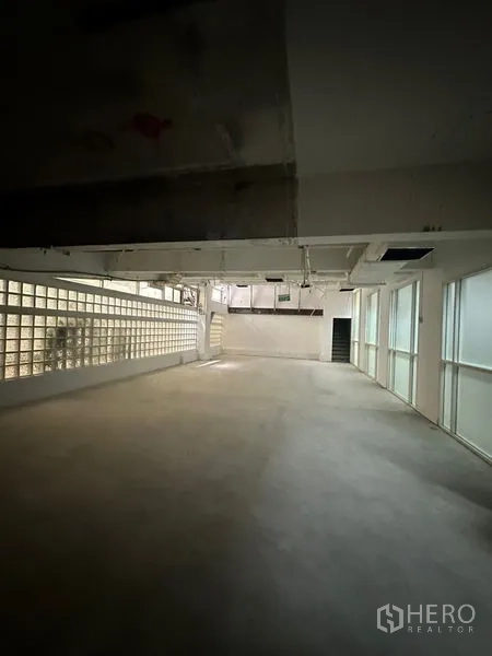 零售空间 出租 - 空置零售空间，侧墙为玻璃砖，窗扇采光，吊顶走管，后方带出入口，布局灵活。