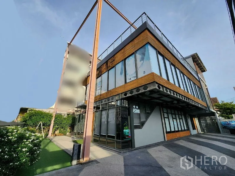 Home Office for rent in Mueang Nonthaburi, Nonthaburi - Contemporary glass-and-steel home office exterior with landscaped lawn and wide driveway.