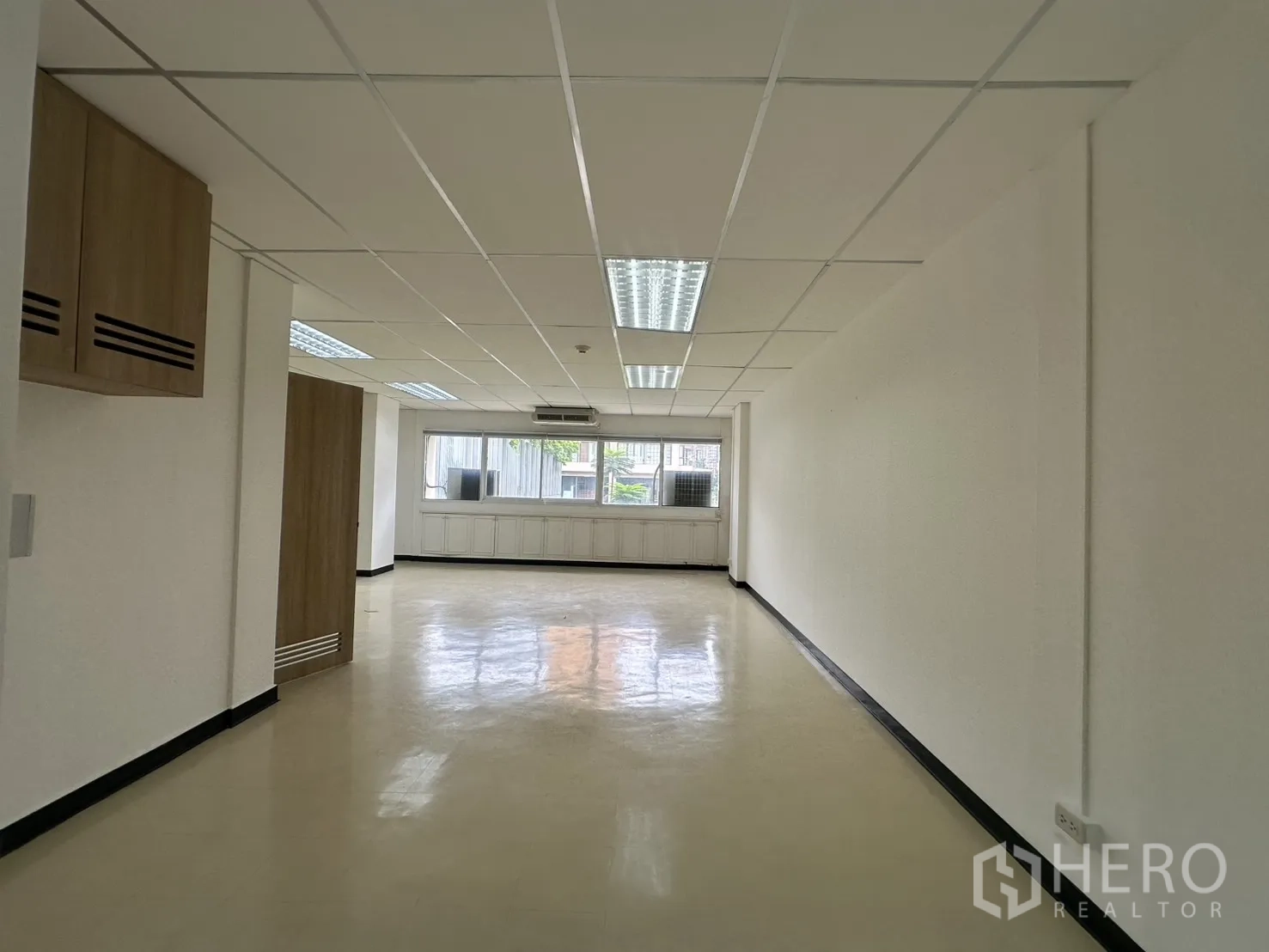 ออฟฟิศ for rent in Pathum Wan, Bangkok - โถงออฟฟิศยาวเพดานแขวนไฟสว่าง เชื่อมไปยังหน้าต่างและตู้บิลต์อินด้านล่าง.