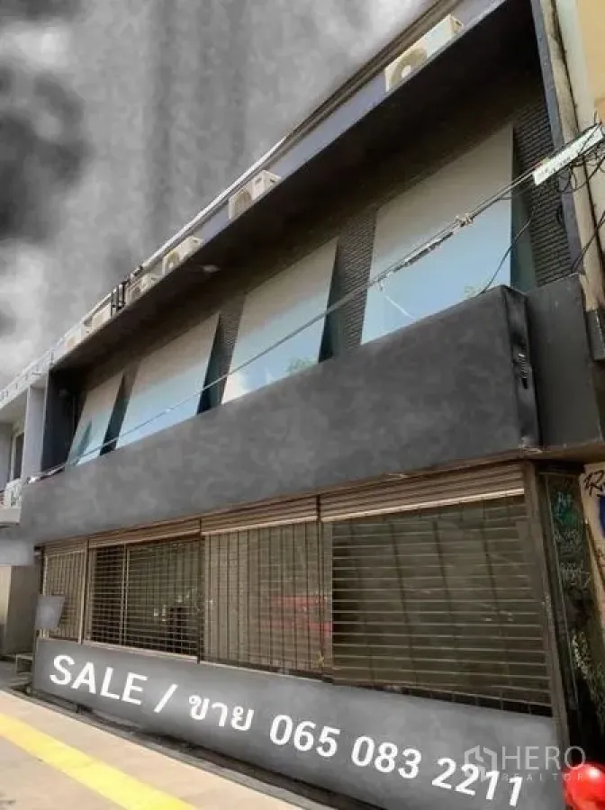 อาคารพาณิชย์ ขายในKhlong Toei, Bangkok - อาคารพาณิชย์ติดถนนด้านหน้า หน้าต่างชั้นบนและประตูม้วนสีเข้ม