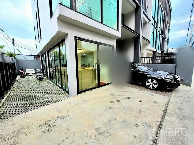 Home Office for sale in Wang Thonglang, Bangkok - Ground-floor glass entrance with driveway and on-site parking beside a modern home office.