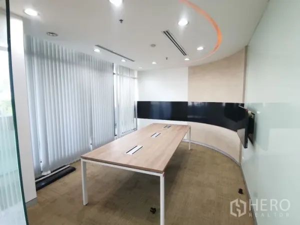 Office Space for rent in Bang Rak, Bangkok - Curved meeting room with long table, vertical blinds and recessed ceiling lights.