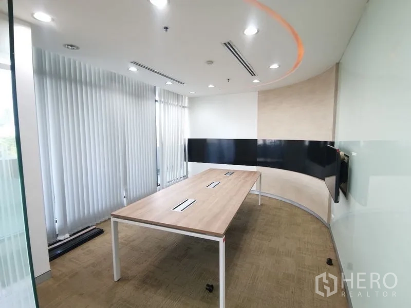 Office Space for rent in Bang Rak, Bangkok - Curved meeting room with long table, vertical blinds and recessed ceiling lights.