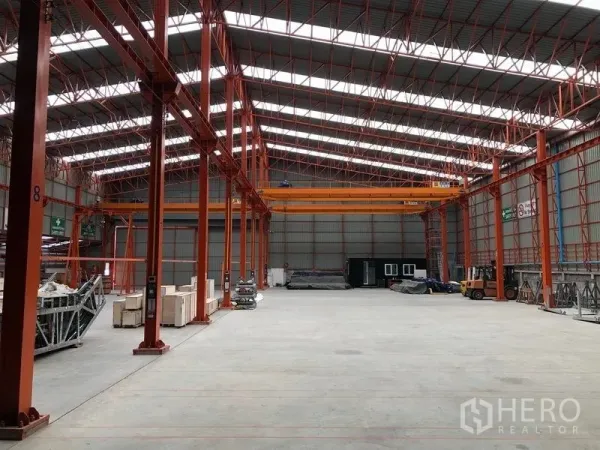 Warehouse for rent in Samut Prakan - Open storage bay with multiple crane tracks, skylights and polished concrete floor.