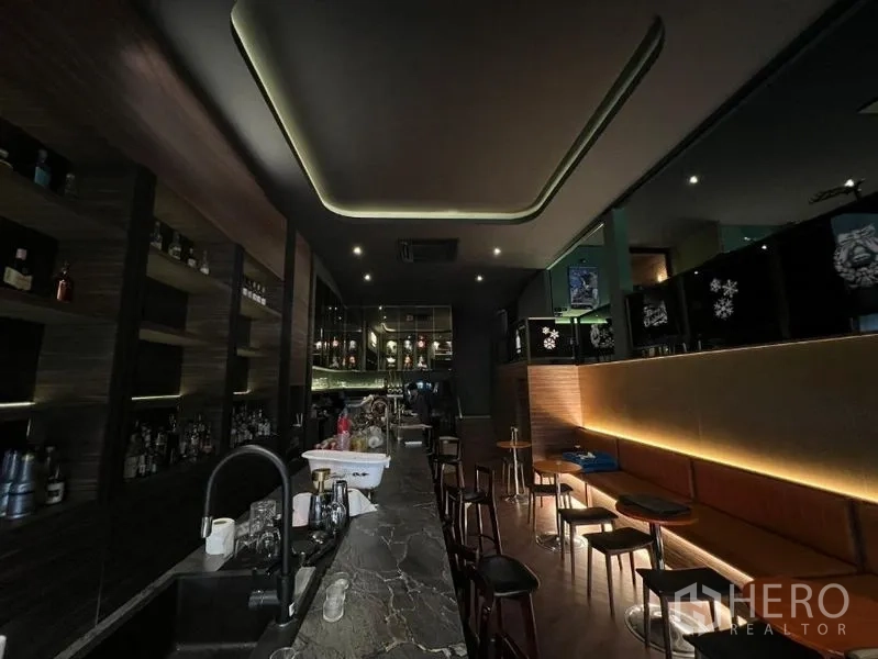 พื้นที่ขายปลีก ให้เช่าในWatthana, Bangkok - ภายในบาร์แสงไฟสลัว เคาน์เตอร์หินยาว ชั้นวางแบบมีไฟ และสตูล