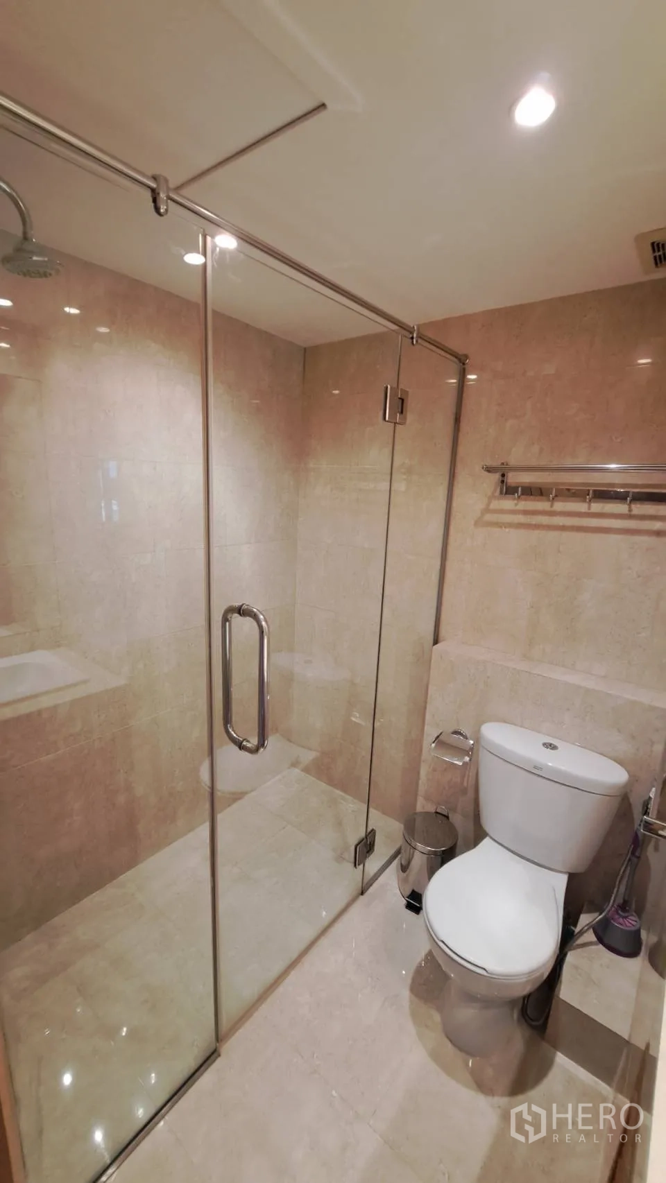 Condominium for rent in Khlong Toei, Bangkok - Bathroom with glass-enclosed shower and modern toilet.