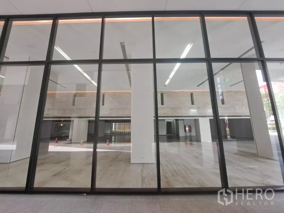 零售空间 出租 - 大面积玻璃店面与双层挑高室内，抛光石材地面明亮通透。