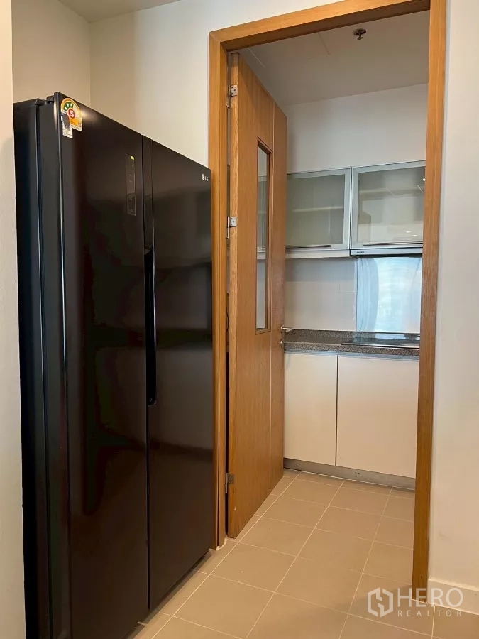 公寓 出租在Khlong Toei, Bangkok - 储物/杂物区，黑色对开门冰箱，通往厨房的门。