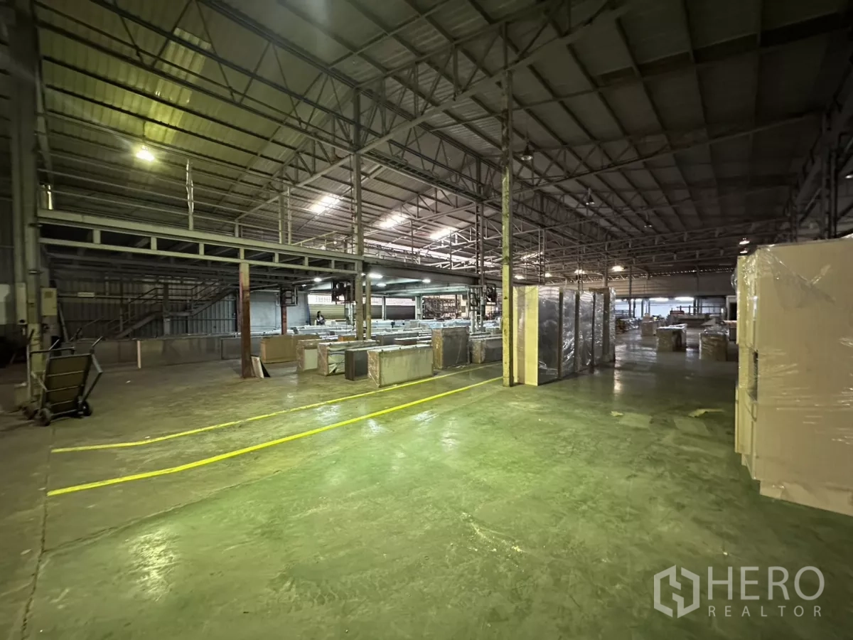 Warehouse for rent in Yan Nawa, Bangkok - Open production floor with mezzanine staircase and clear traffic lines.