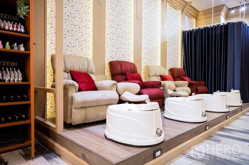 零售空间 出租在Khlong Toei, Bangkok - 多张舒适足疗椅与足浴盆置于抬高平台，旁有产品货架。