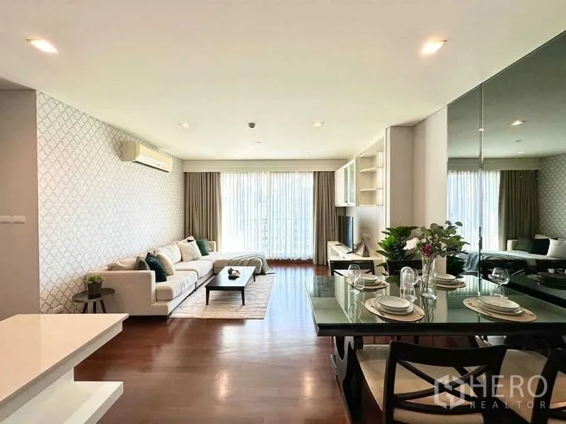 公寓 出租在Watthana, Bangkok - 宽阔客餐厅，整面落地窗帘与特色墙面。