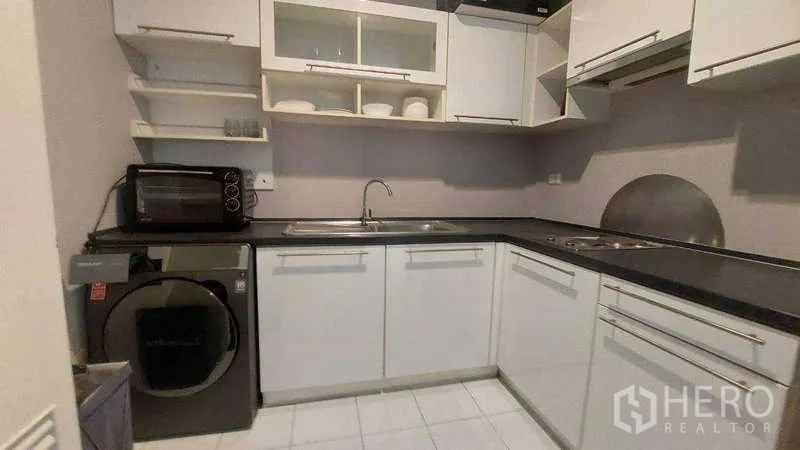 คอนโด ให้เช่าในWatthana, Bangkok - ครัวรูปตัวแอล พร้อมอ่างล้างจาน เตาไฟฟ้า และเครื่องซักผ้าฝาหน้า