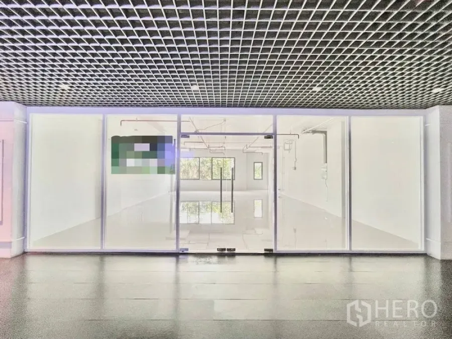 พื้นที่ขายปลีก ให้เช่าในKhlong Toei, Bangkok - มุมมองจากโถงทางเดินสู่หน้าร้านกระจกเต็มความสูง พร้อมประตูคู่ และเพดานตะแกรง