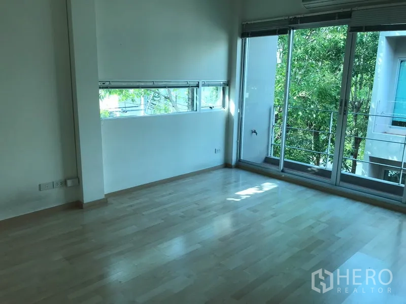 ทาวน์เฮาส์ ให้เช่าในSuan Luang, Bangkok - ห้องนอนมุมมีช่องหน้าต่างยาวและระเบียงมองเห็นต้นไม้