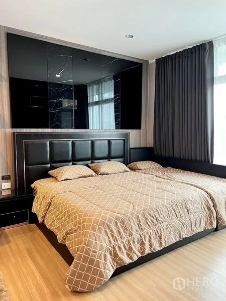 Townhouse for rent in Saphan Sung, Bangkok - Master bedroom with padded headboard, large bed and floor-to-ceiling curtains.
