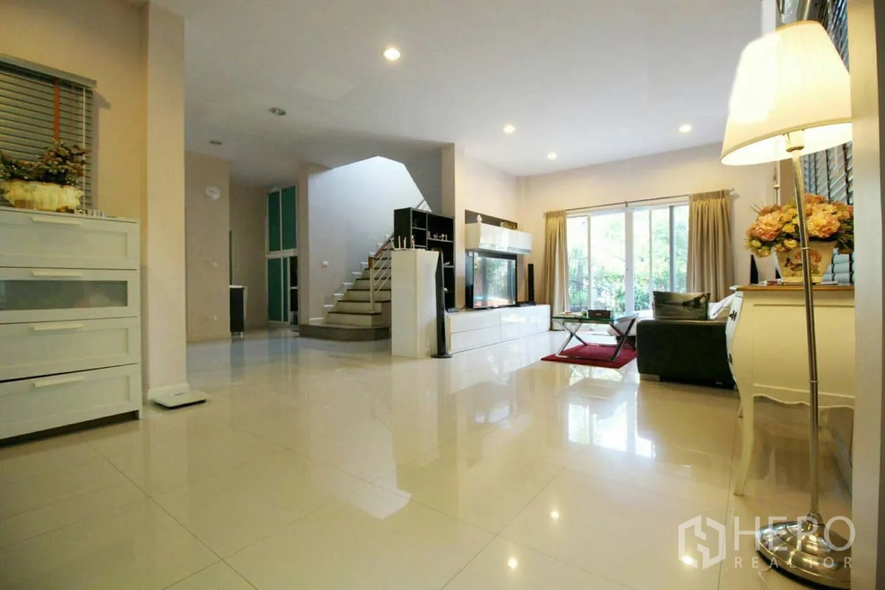 บ้าน ให้เช่าหรือขายในLat Krabang, Bangkok - ห้องนั่งเล่นกว้าง พื้นกระเบื้องเงา บันได ทีวีวอลล์ และประตูกระจกสไลด์ออกสวน