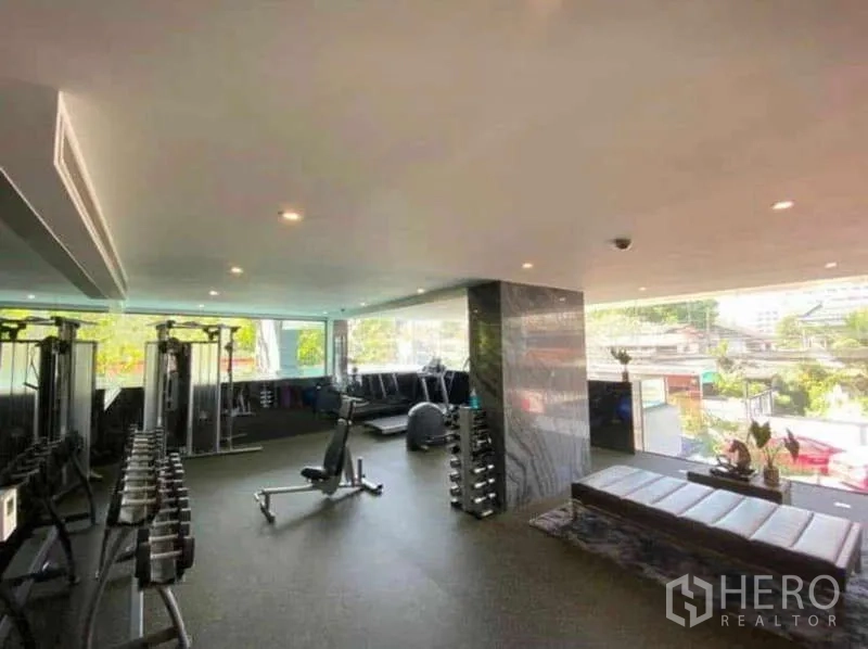 Condominium for rent in Khlong Toei, Bangkok - Fully equipped fitness room with weights and cardio machines overlooking the city.
