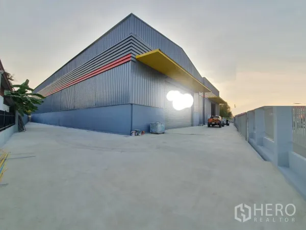 货栈 出租在Sai Mai, Bangkok - 曼谷赛迈区现代钢结构仓库外观，带卷闸门与宽阔混凝土车道。