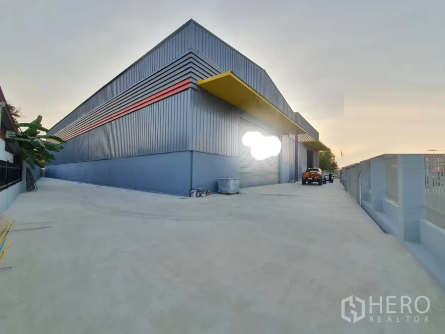 货栈 出租在Sai Mai, Bangkok - 曼谷赛迈区现代钢结构仓库外观，带卷闸门与宽阔混凝土车道。