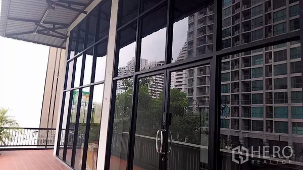 พื้นที่ขายปลีก ให้เช่า - ด้านหน้ากระจกสูงจรดเพดานพร้อมระเบียง เห็นวิวคอนโดรอบๆ