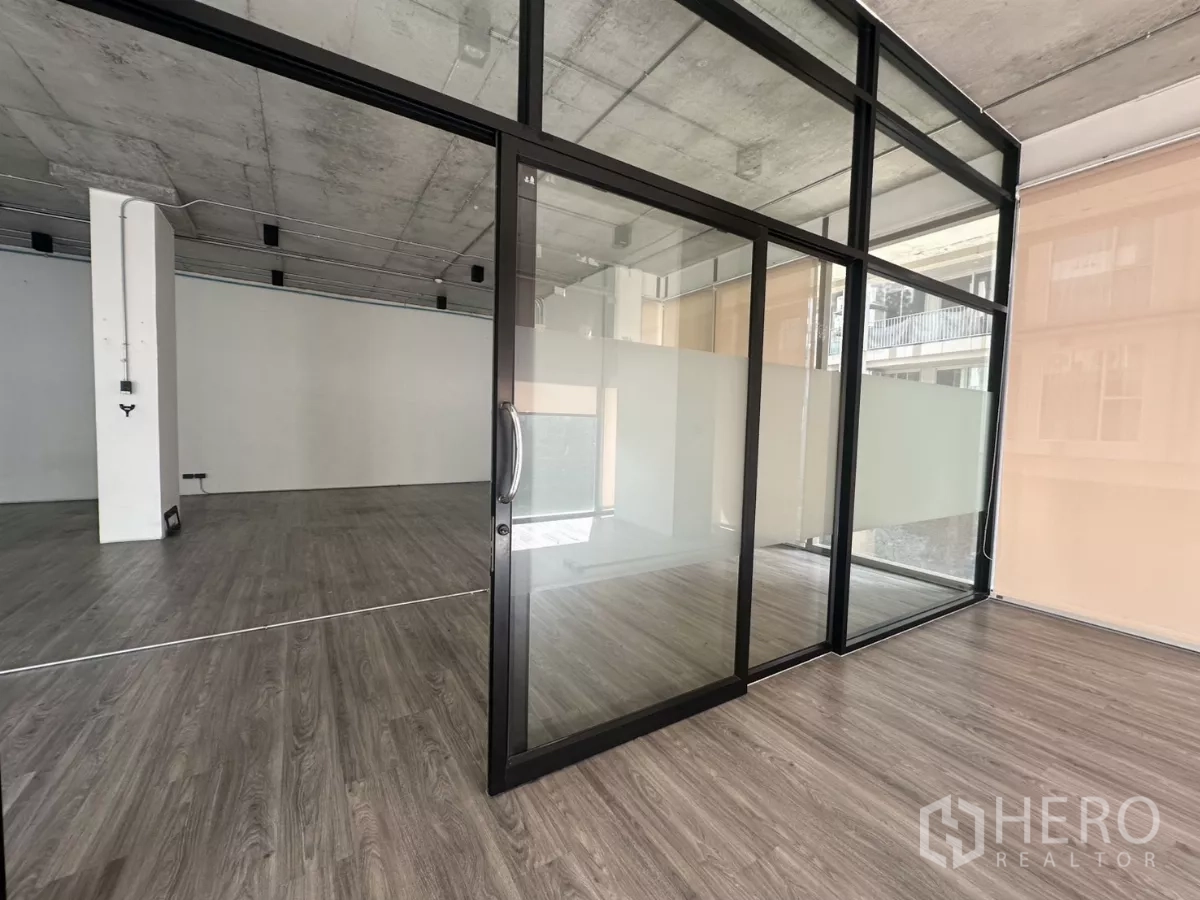 零售空间 出租 - 黑色框架玻璃隔间特写，滑门与磨砂玻璃面板。