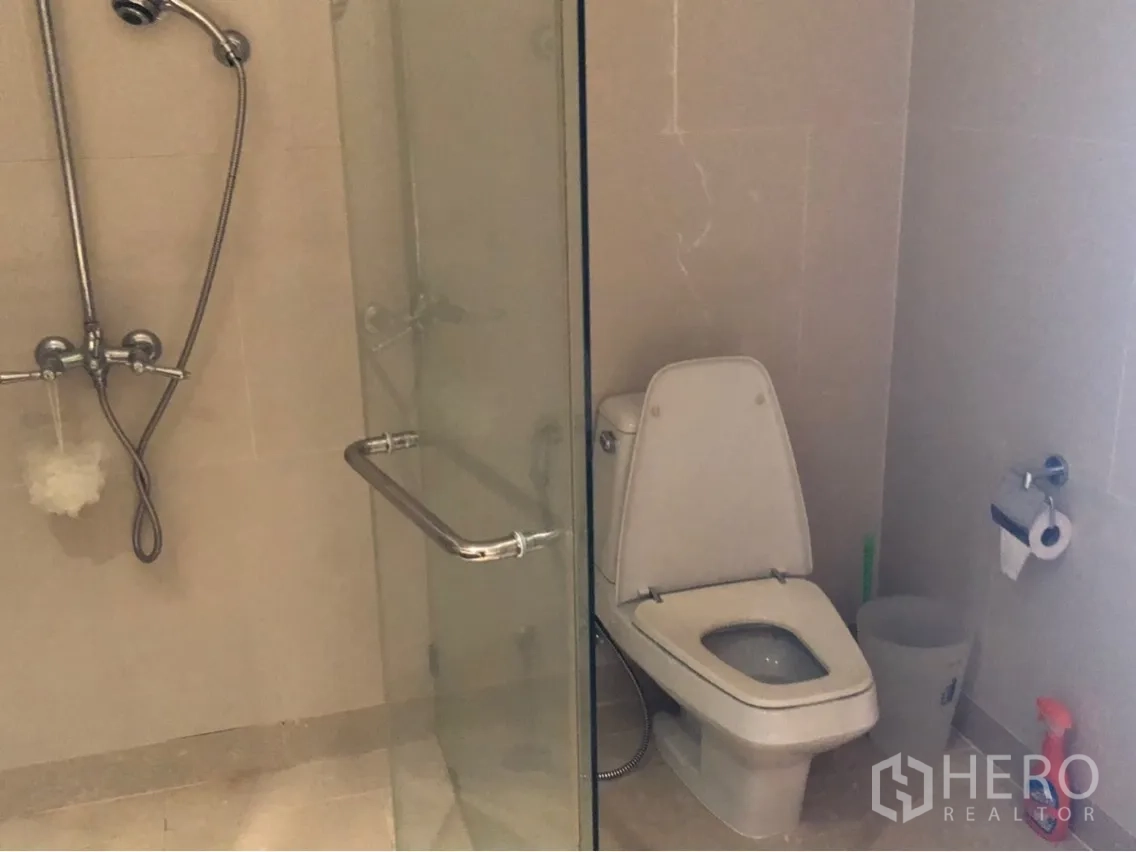 公寓 出租或出售在Sathon, Bangkok - 次卫设玻璃淋浴间与坐便器，米色瓷砖。