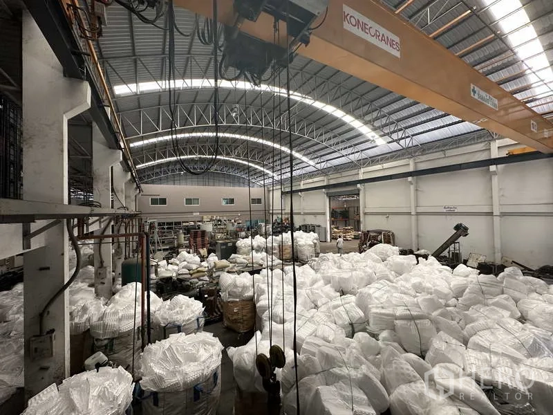 Factory for rent or sale in Khlong Luang, Pathum Thani - Overhead crane system and process lines above bulk material bags.