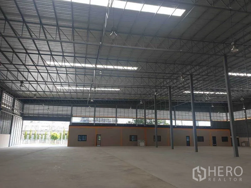 Warehouse for rent in Chachoengsao - Wide warehouse hall featuring an internal office block and continuous ventilation louvers.